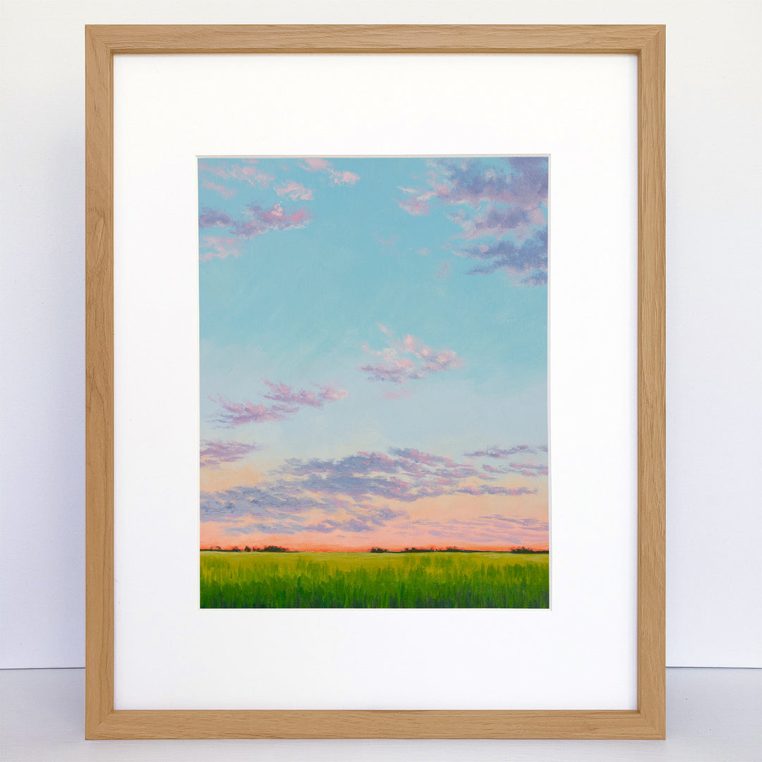 A framed art print of a peaceful evening sunset with pastel blues, pinks, greens, purples, and oranges.
