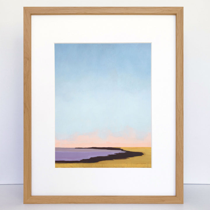 Framed print of an abstract landscape scene with purple water, tan shore, and pink and blue sky.