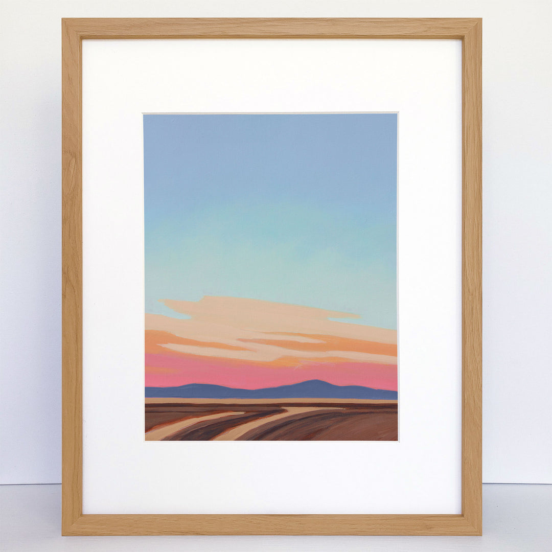 Framed art print of minimalist sunset scene with brown and tan foreground.